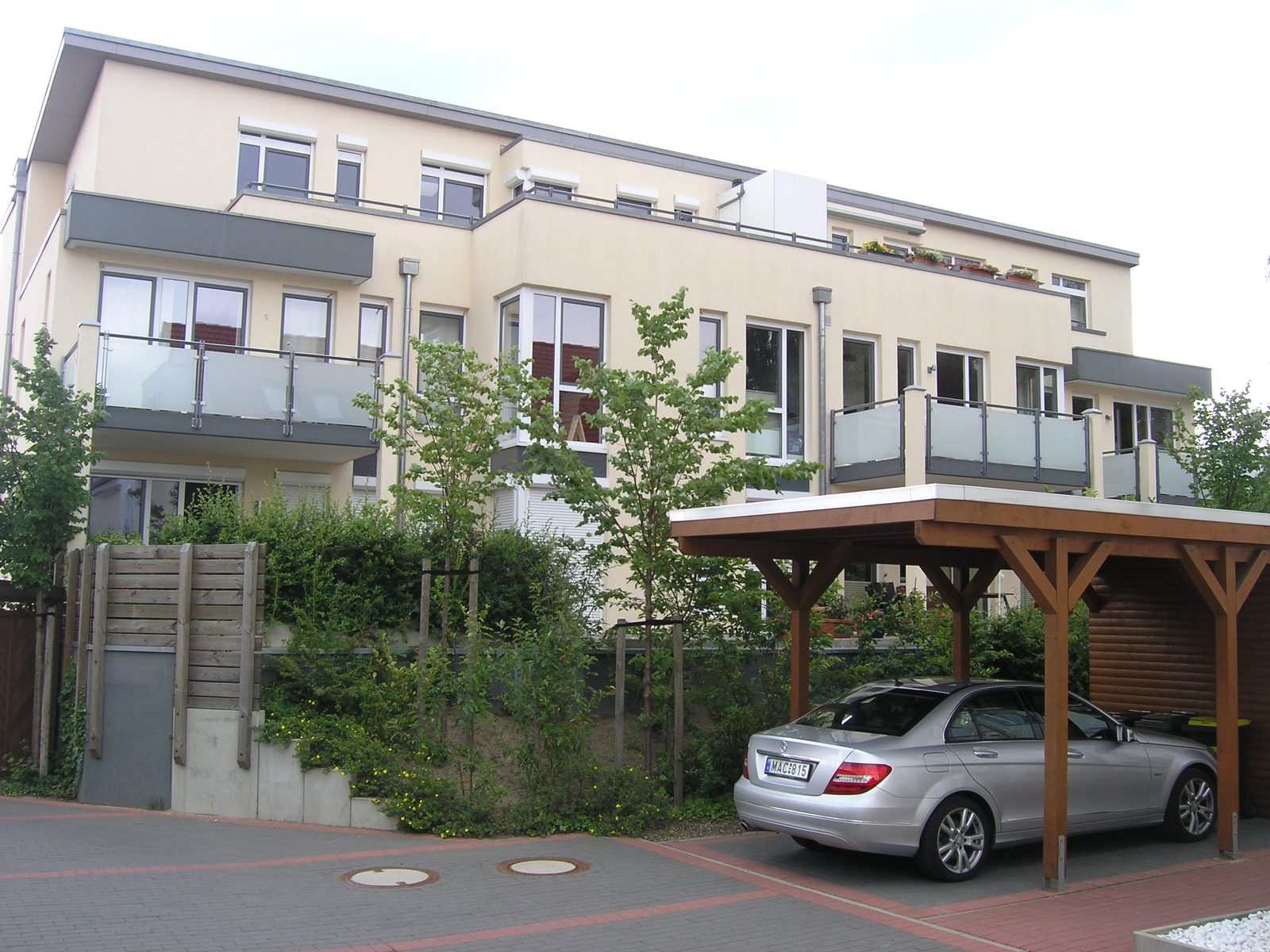 Gartenseite mit Balkonen, Dachterrassen und Carport