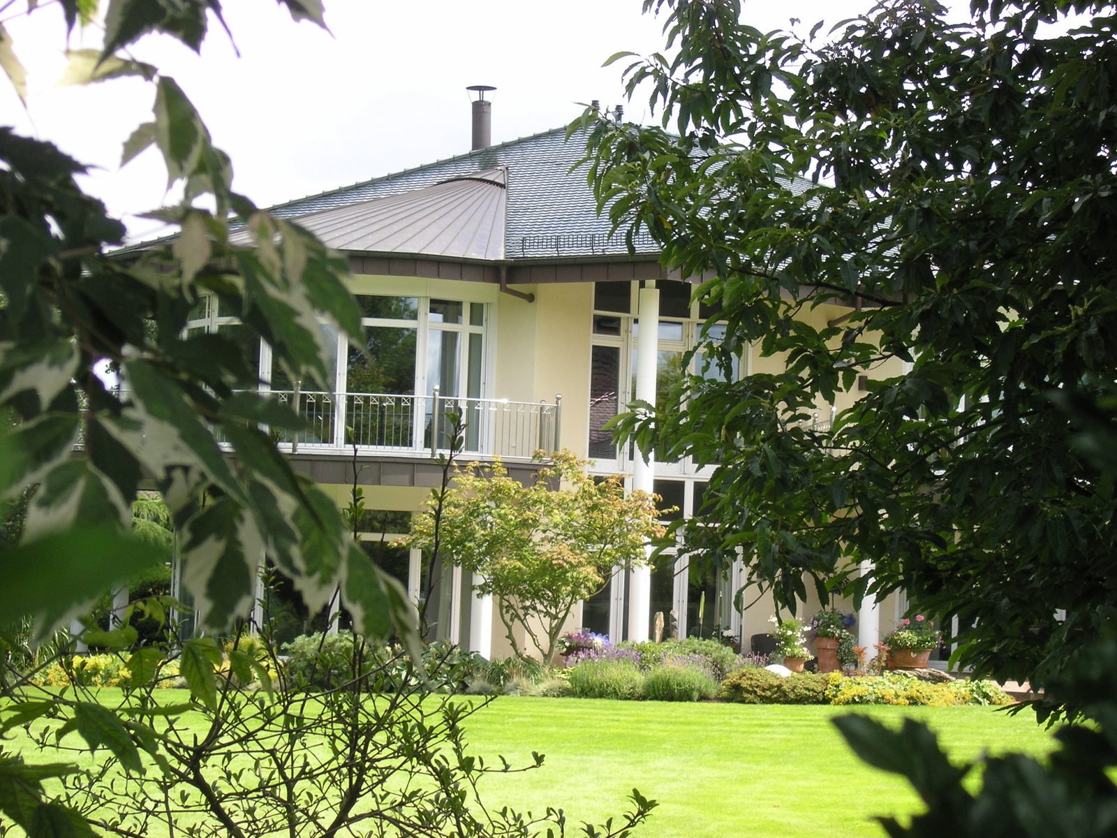Gartenseite mit Terrasse und Säulengang