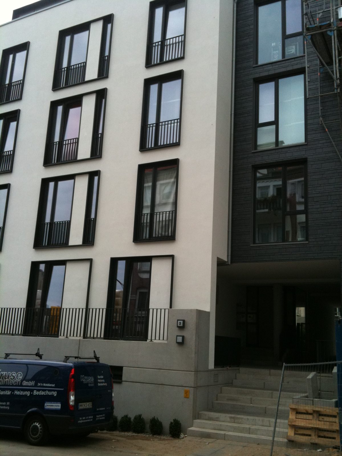 Hauseingang zwischen Putz- und Schieferfassade