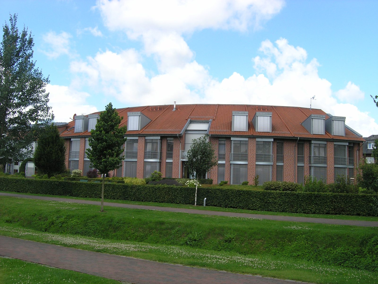 Blick vom Weg über die Grünfläche auf den Rundbau