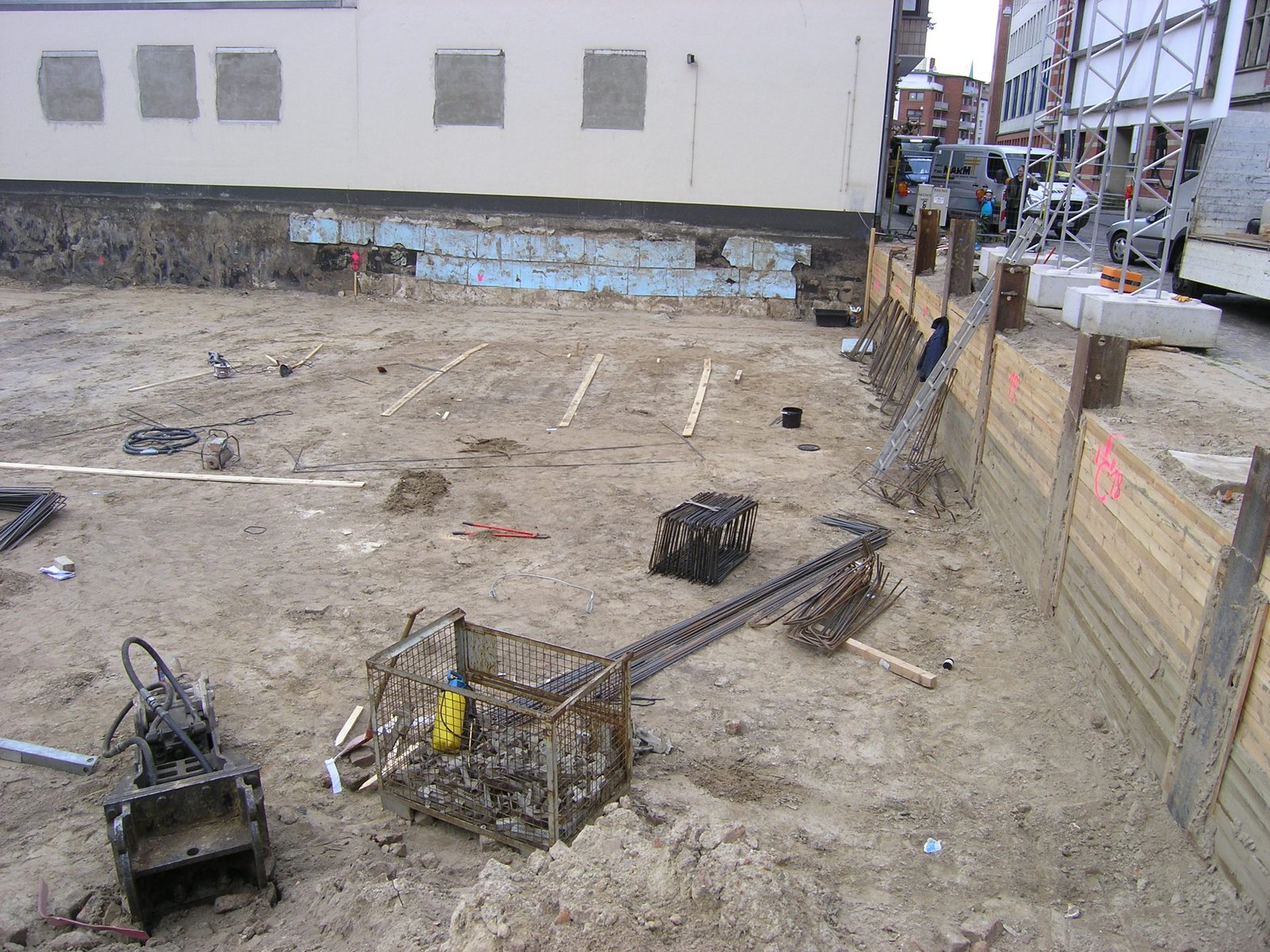 Die ausgehobene Baugrube mit dem Holzverbau zur Straße